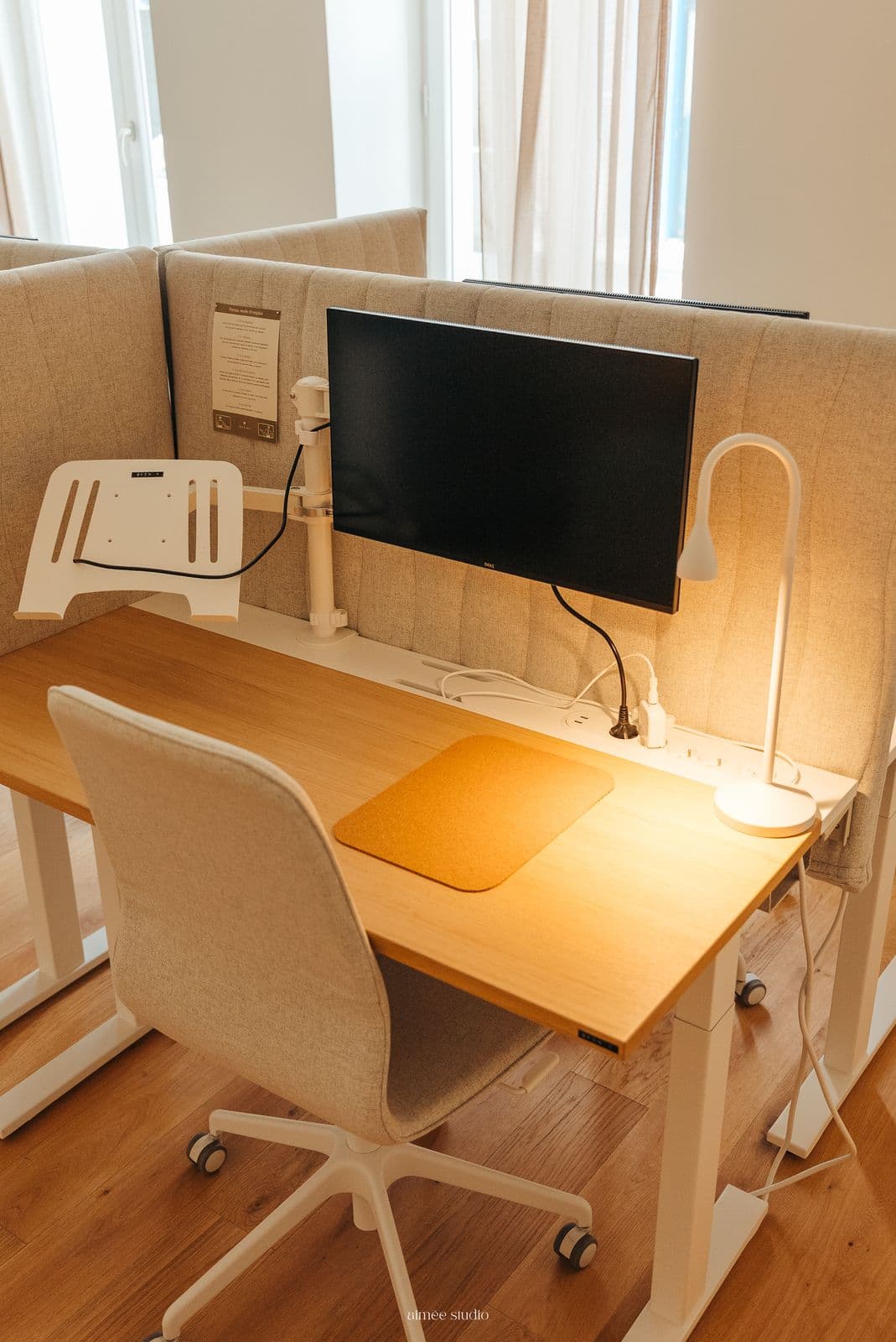 Un bureau Open avec écran 24 pouces, lampe et cloison acoustique