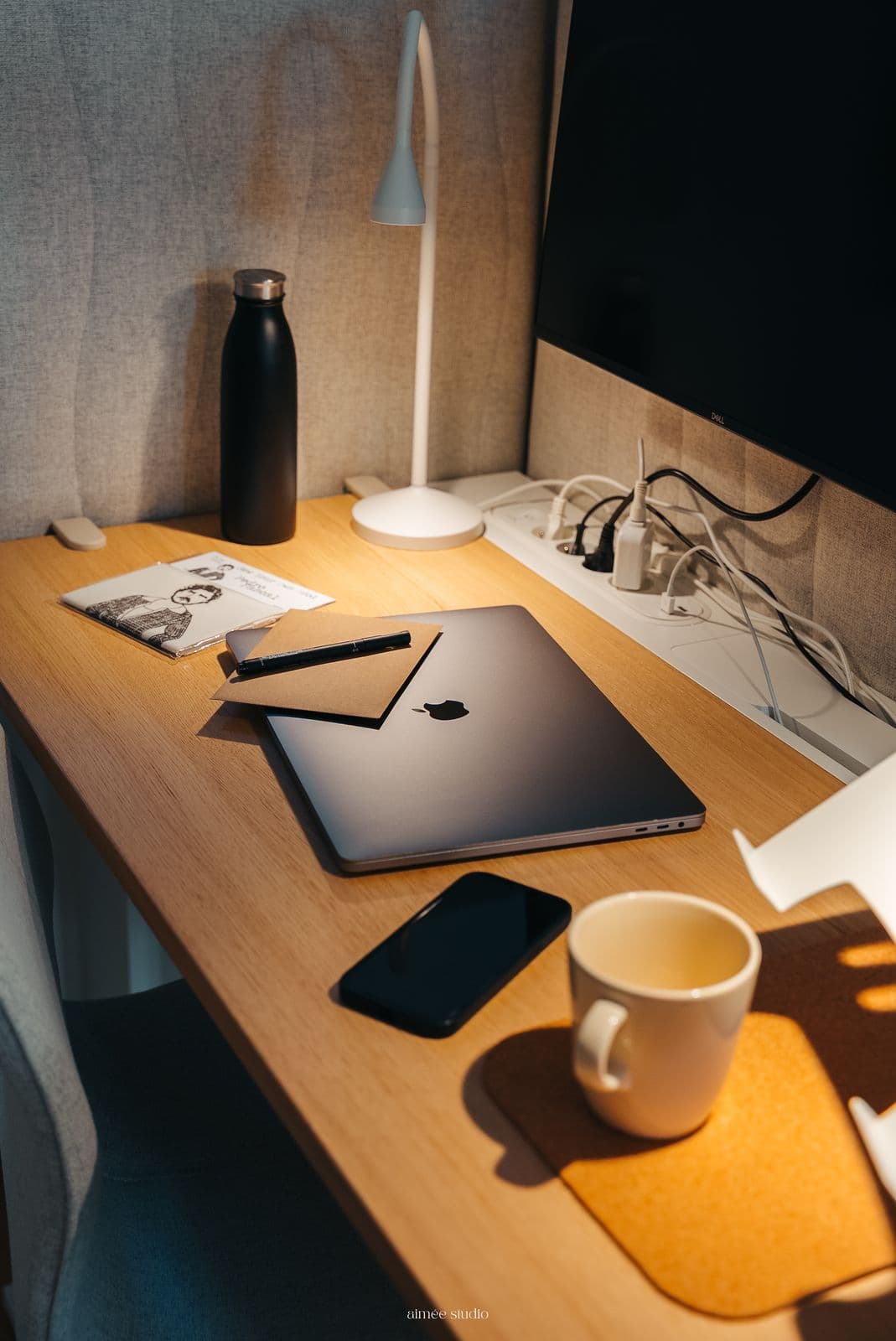 Un bureau avec ordinateur portable, téléphone et tasse de café