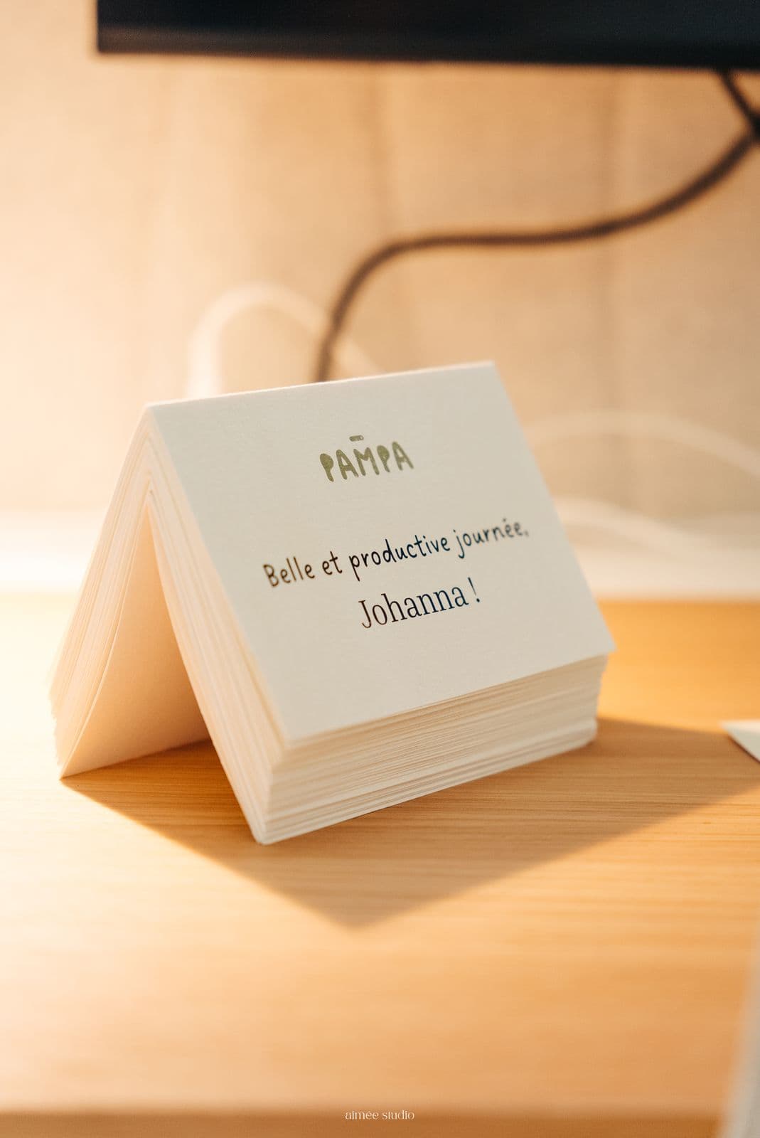 Carte de bienvenue « Belle et productive journée » posée sur un bureau